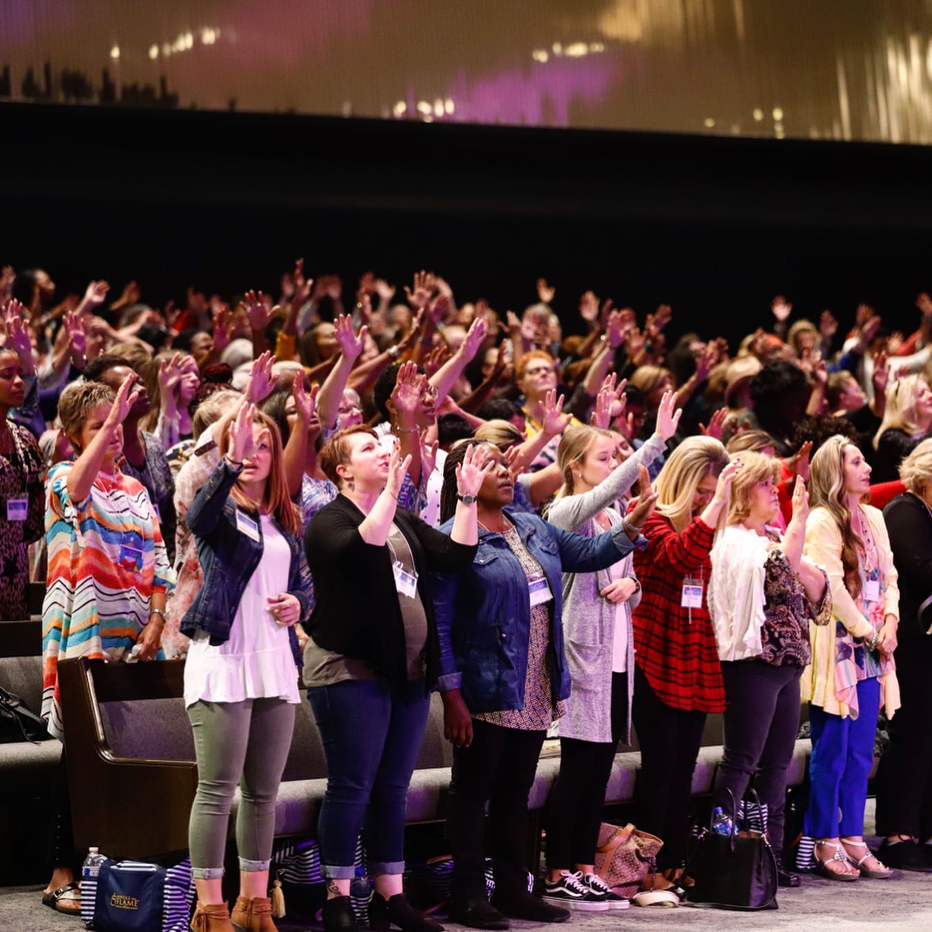 women raising their hands - Kindle the Flame