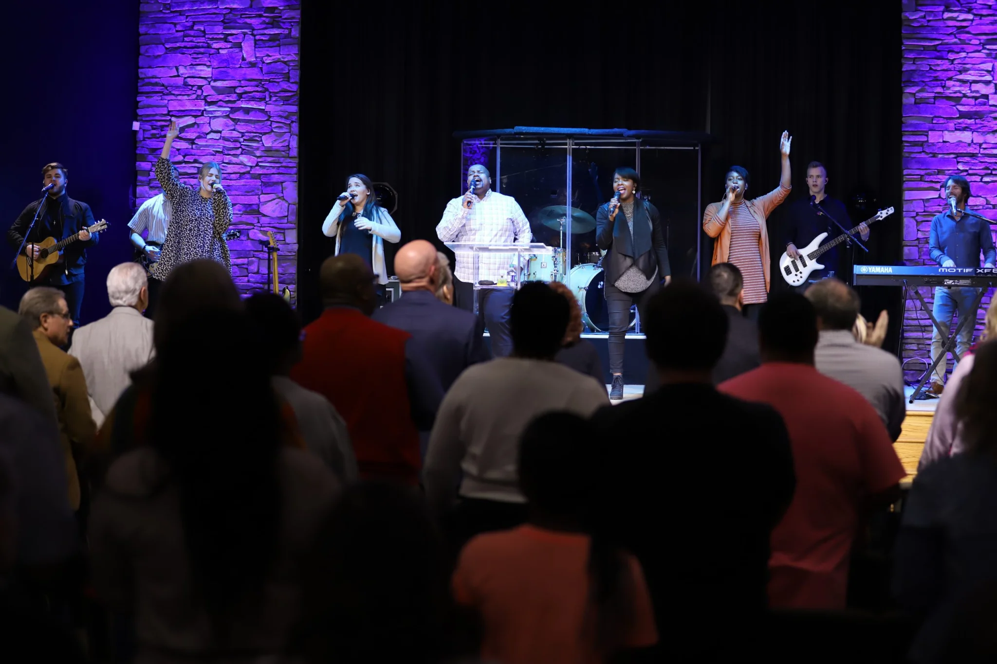 Rhema Band singing on the altar, and people in the front of the church
